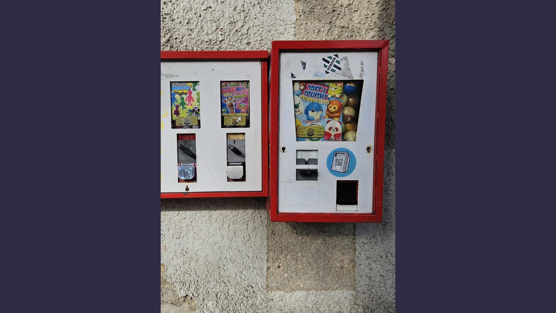 Foto: Zwei rostige Kaugummi-Automaten an einer heruntergekommenen Hauswand, von der der Putz abbröckelt
