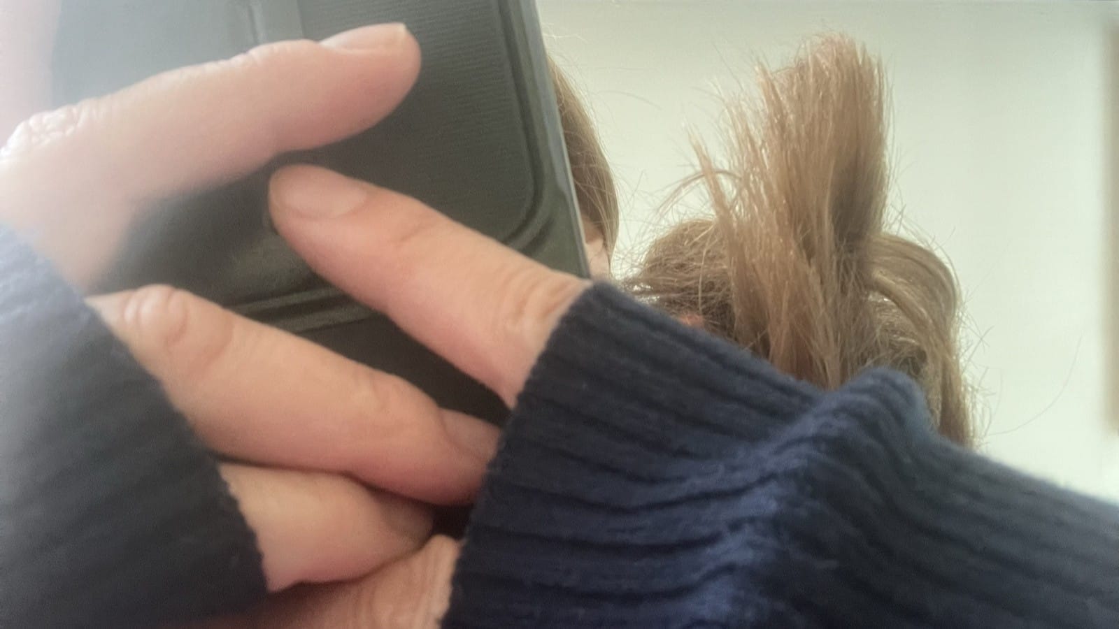 Hände mit Armstulpen halten ein Smartphone