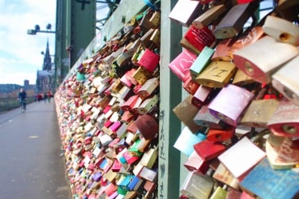 Foto vom Geländer der Hohenzollernbrücke mit unzähligen bunten Liebesschlössern am Geländer.