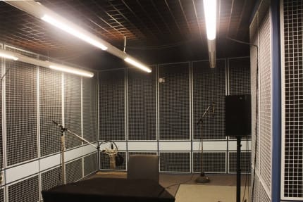 Foto: Ein Tonstudio des WDR, grauer Schallschutz an den Wänden und ein Sitzplatz mit einem Mikrophon an einem Stativ.