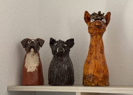 Foto: Drei Ton-Figuren auf einem Regalbrett: ein Hund, ein Wildschwein und ein Alpaka