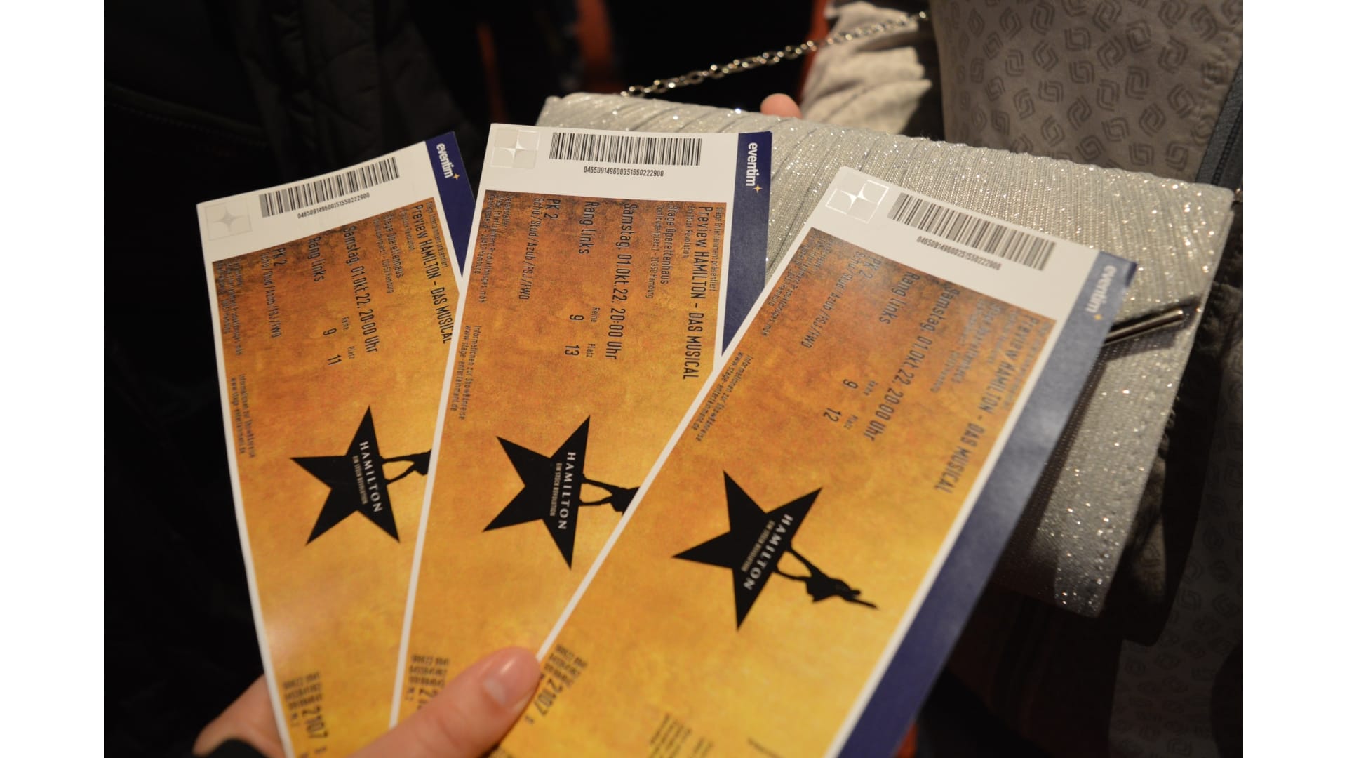 Unsere Tickets- Gold mit einem schwarzen Stern dessen obere Spitze die Silhouette von Hamilton ist.