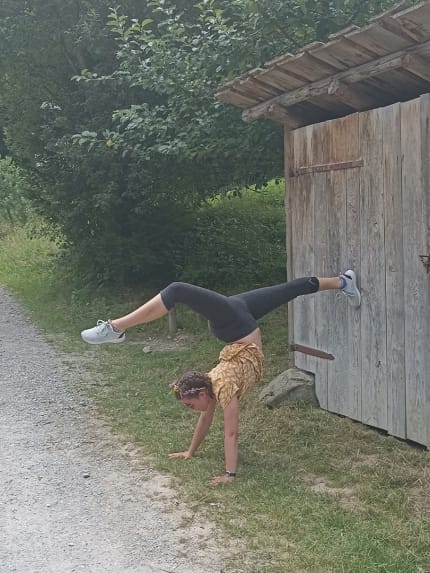 Hannah im Handstand mit den Beinen im Spagat.