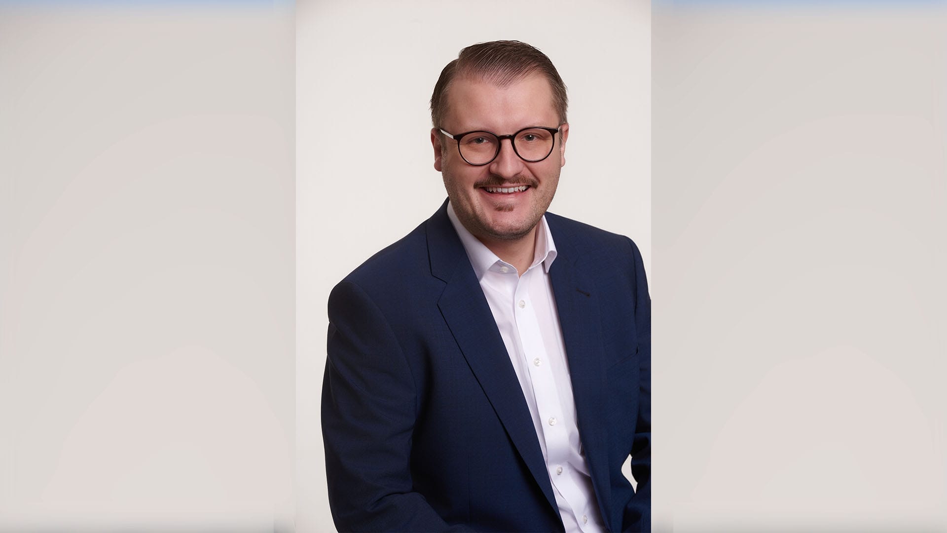 Professionelles Portrait eines Mannes in Hemd, Jackett und mit Brille