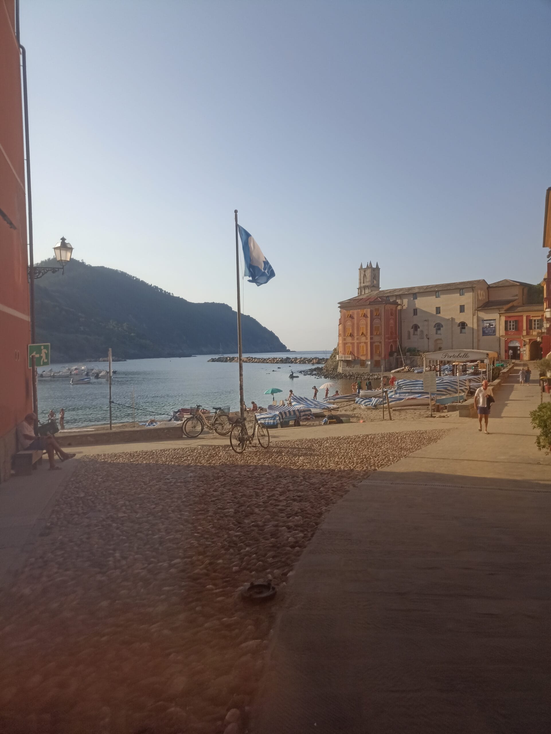 Strand mit bunten Häusern und Berg mit Wald im Hintergrund