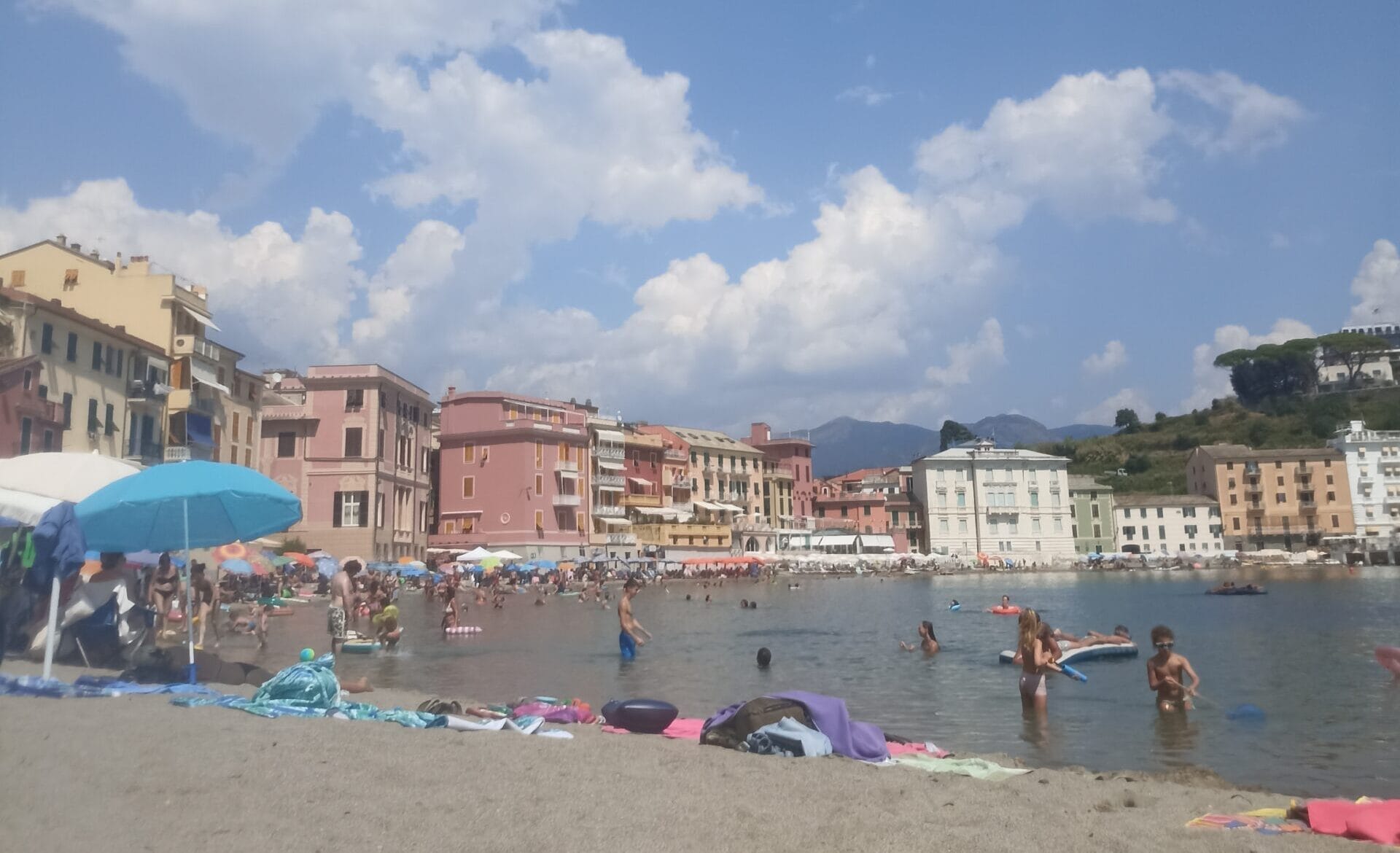 Bunte Häuser an einem Sandstrand bei schönem Wetter.