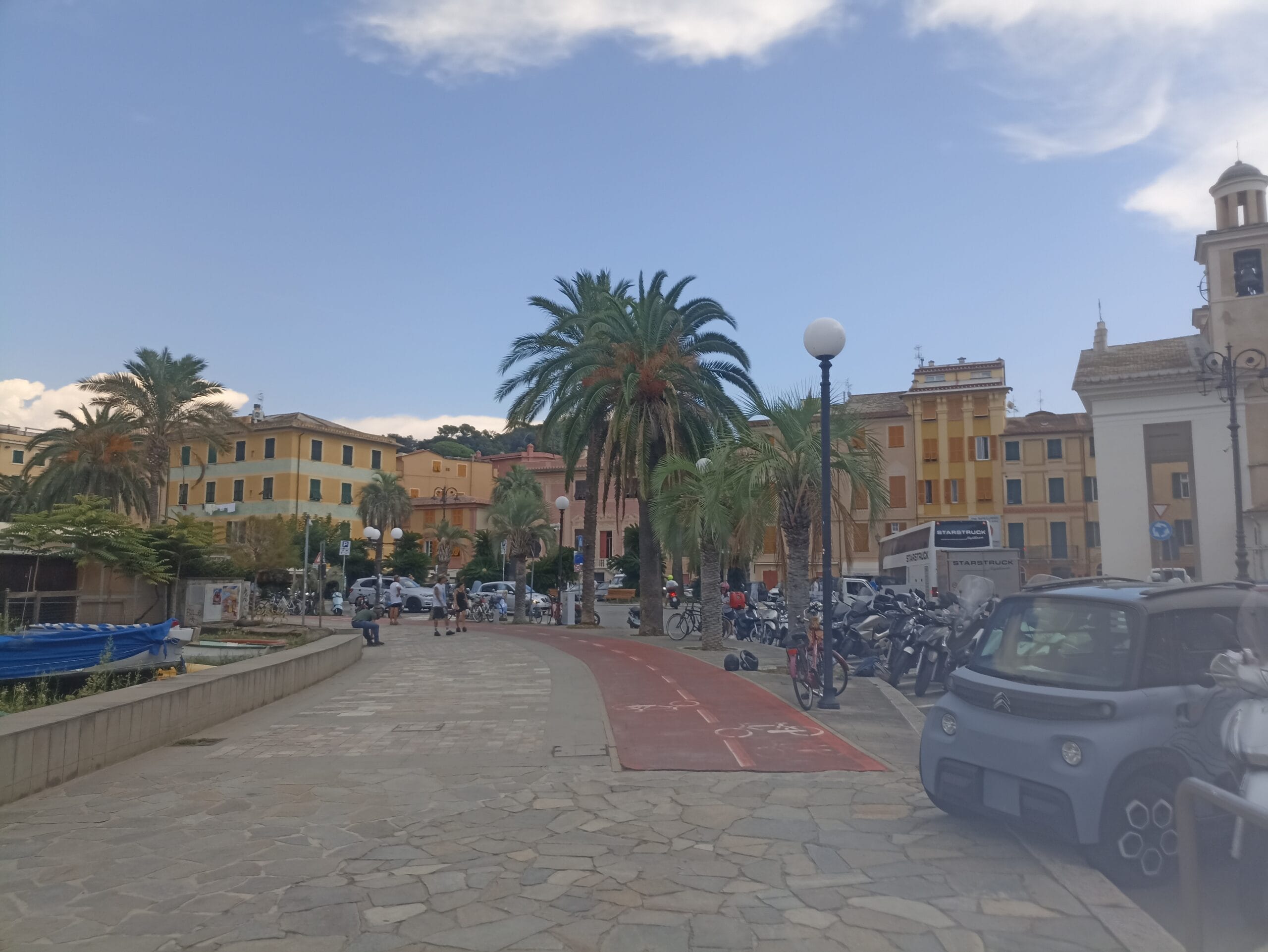 Foto: Ein schöner Platz mit orange-gelben Häusern und hohen Palmen