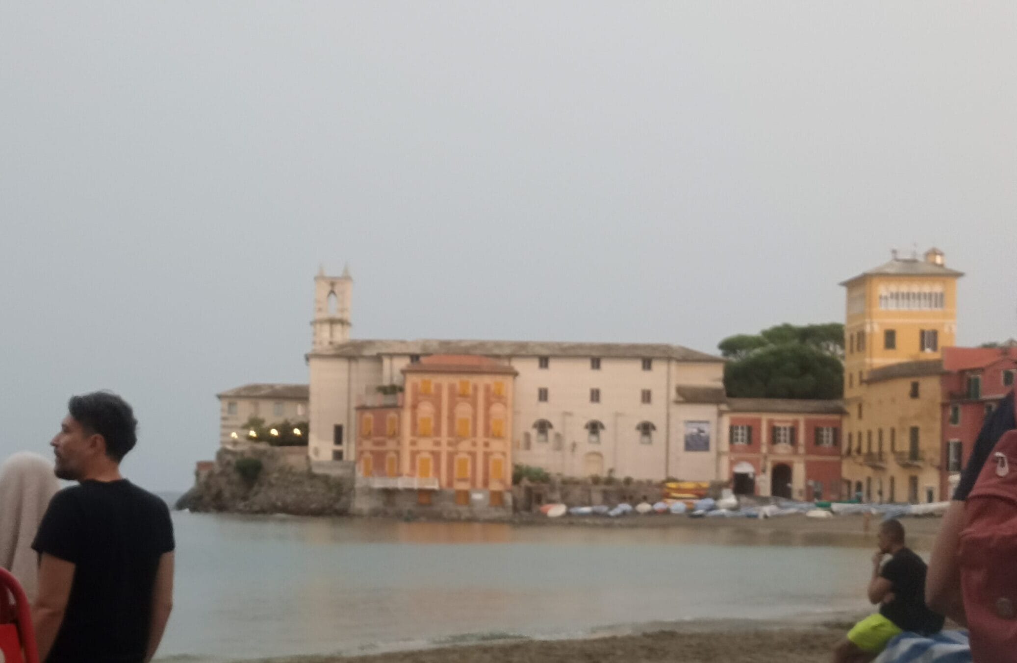Foto: Ein Kloster hinter einer Bucht und davor im Wasser kleine Boote