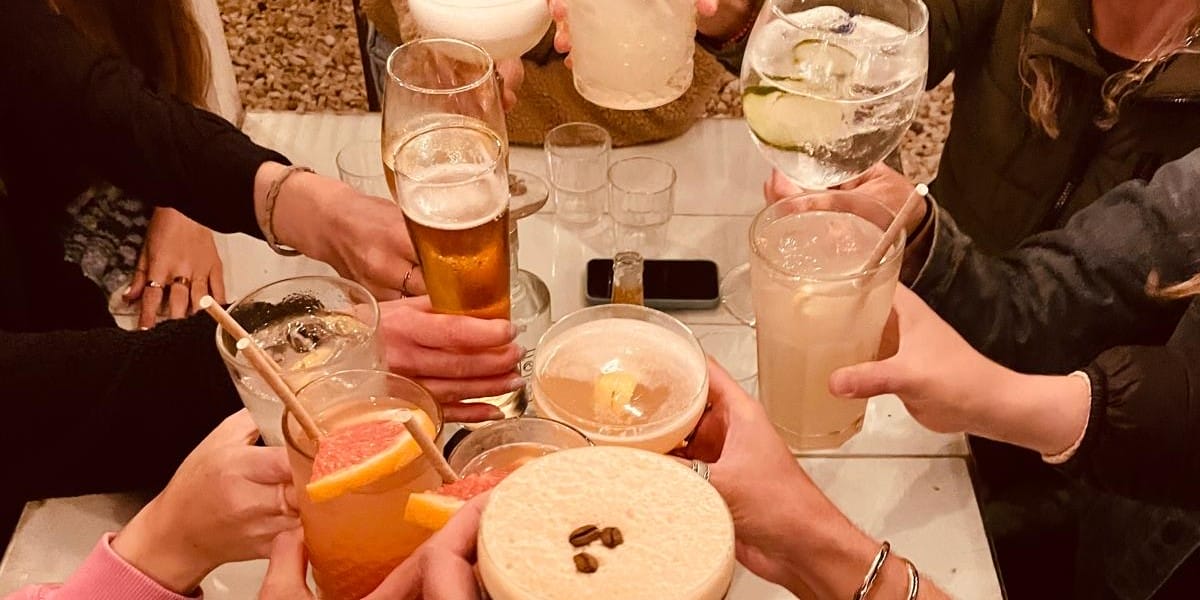 Foto: An die 10 Gläser mit verschiedenen Getränken werden zum Anstoßen in die Mitte gehalten