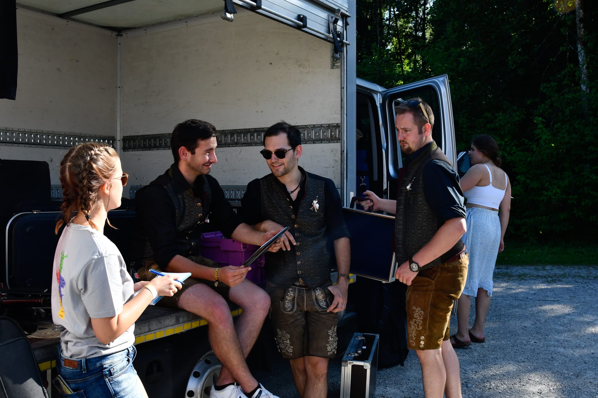 Foto: aROund Reporterin Hannah mit Stift und Block bei vier Bandmitgliedern an einem offenen Transporter