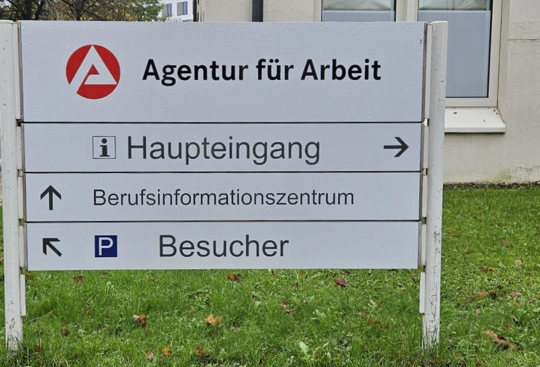 Foto: Eine Wegweiser-Tafel vor der Agentur für Arbeit Rosenheim mit Pfeilen zum Haupteingang und zum BiZ