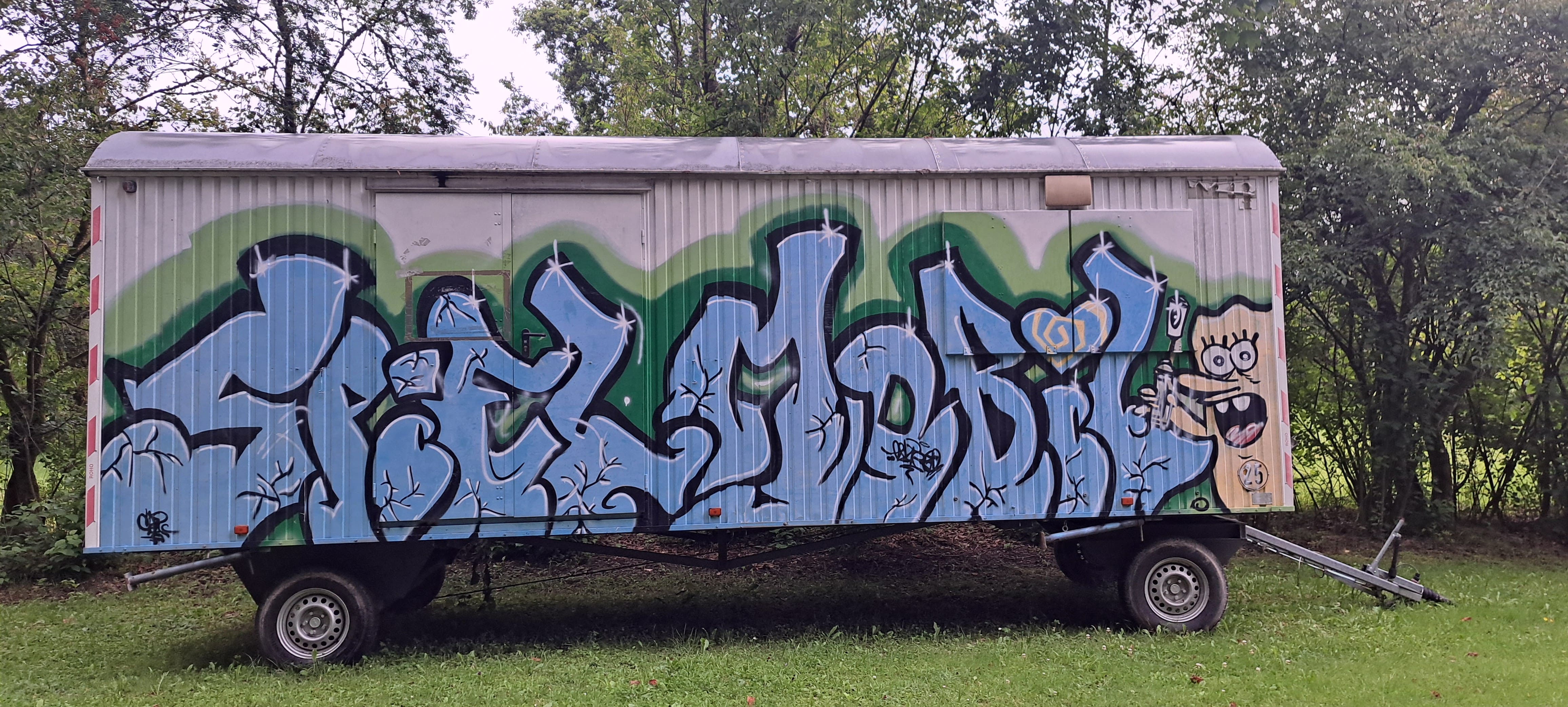 Foto vom Bauwagen des Sielmobils auf den in Grafity Schrift SPielmobil gesprayt ist